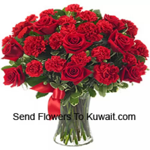 12 Red Roses And 12 Red Carnations With Some Ferns In A Glass Vase